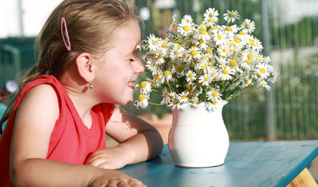 Flicka luktar på blommor och undrar om allergi är ärftligt
