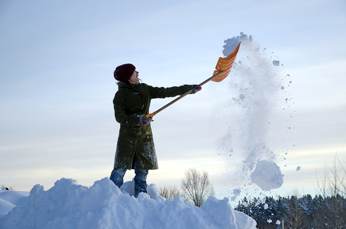 Man som skottar snö